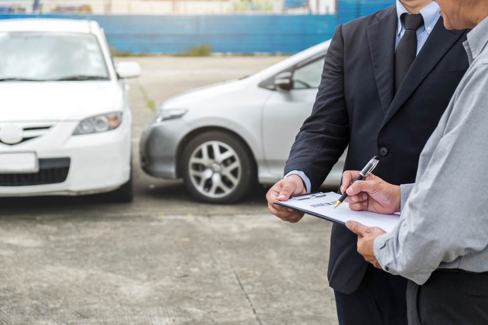 Insurance agent completing car accident claim paperwork